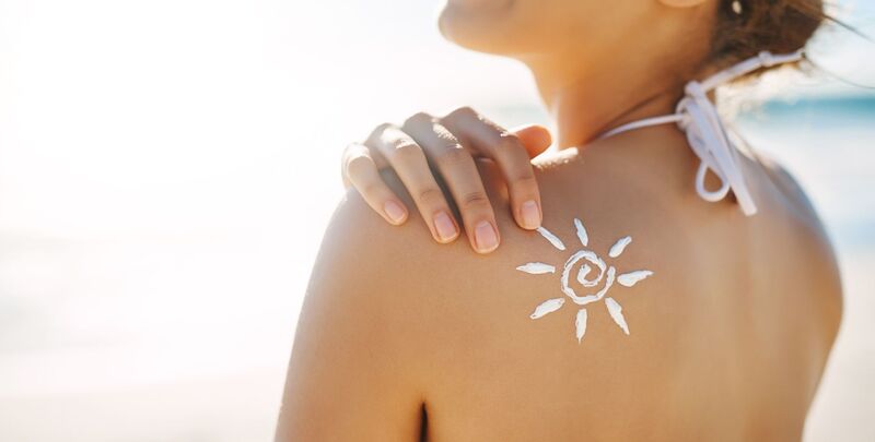 Frau mit Sonnencreme auf dem Rücken