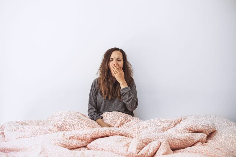 Eine Frau liegt müde im Bett