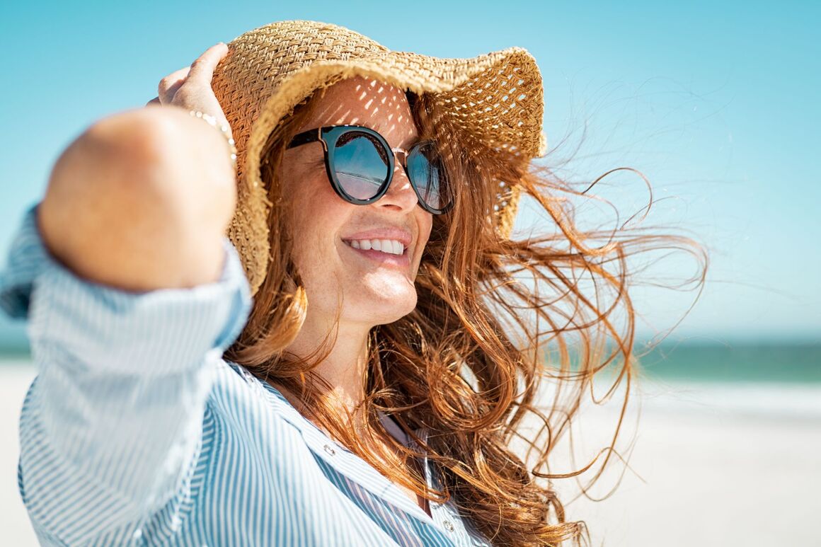 Eine Frau am Strand mit Sonnenhut
